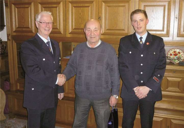 Friedolin Weiler (Mitte) ist für 60 Jahre Mitgliedschaft in der Feuerwehr mit einem Präsent geehrt worden. privat