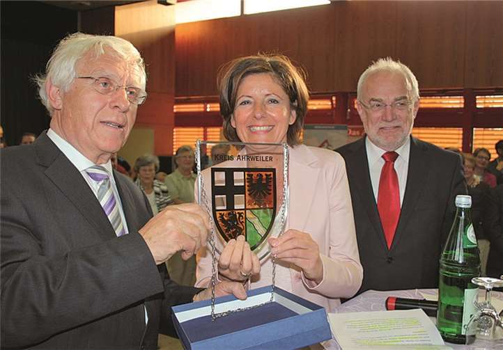 Fritz Langenhorst überreicht Malu Dreyer ein Gastgeschenk aus Ahrweiler, daneben Oberbürgermeister Nikolaus Roth.