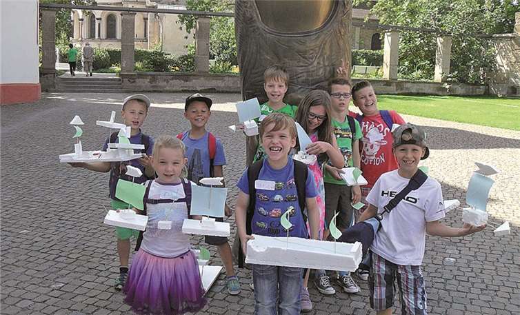 Fröhlich präsentieren die Kinder ihre selbst gebauten Boote aus Styropor.  Privat