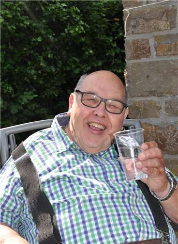 Früher ist Hans-Jürgen Johnen gerne selbst gewandert, aber jetzt schmerzen die Knie zu sehr. Deshalb macht er sich bei der Wasserausgabe nützlich.