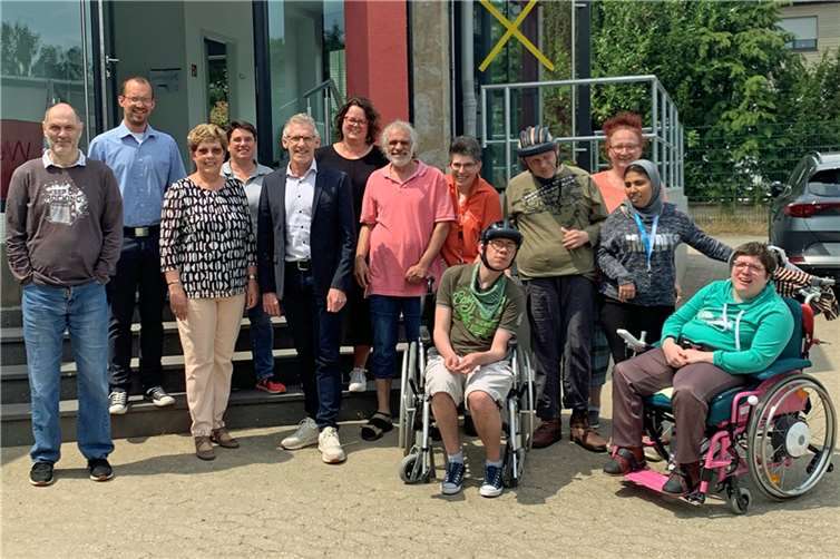 Führungskräfte, Mitarbeitende und Werkstattbeschäftigte der Caritas Werkstätten Sinzig mit Vermieterin Mechthild Henneke (3.v.l.) vor dem Eingang von Werk III.  Foto: Caritas Werkstätten Sinzig