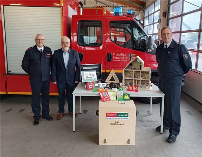 Für die Aufklärungsarbeit der Feuerwehr übergab Provinzial Geschäftsstellenleiter Wolfgang Cremer ein Rauchhaus an Wehrleiter Christian Klein und an den zuständigen Brandschutzerzieher Rainer Klein von der Feuerwehr Swisttal. Foto: privat