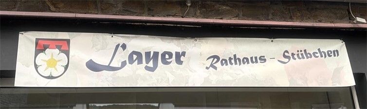 Für eine besondere Überraschung sorgten zwei Layer Bürger, die eigens ein Banner gestaltet hatten. Darauf gaben sie den neuen Räumlichkeiten kurzerhand den Namen „Layer Rathaus-Stübchen“.