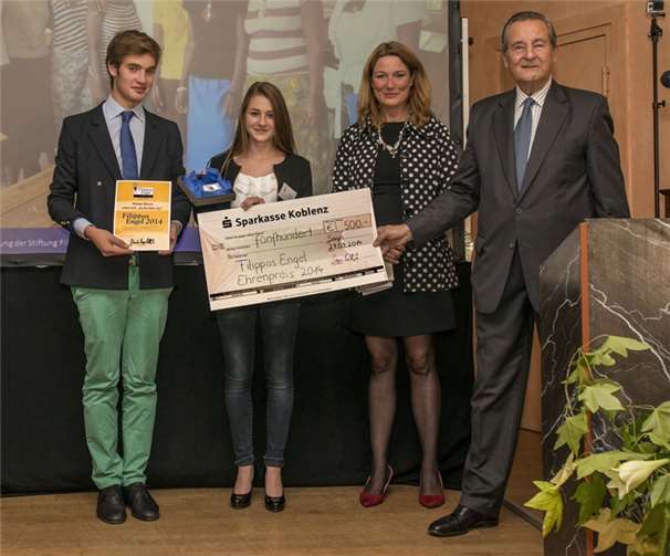 Fürst Alexander zu Sayn-Wittgenstein, Moderatorin Heike Boongarten und ein Enkelsohn des Fürsten gratulierten der Schülerin Anna Bach, stellvertretend für die gesamte Burundi AG der Schönstätter Marienschule.