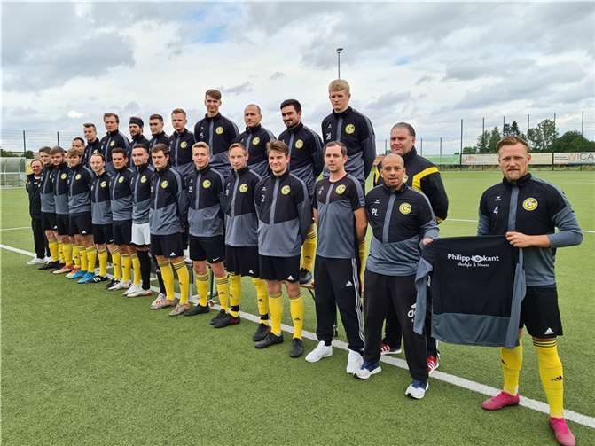 GSG-Kapitän Daniel Schäfer (rechts) nimmt die neuen Aufwärmpullis von Philipp Loskant (vorne 2. v.r.) entgegen. Foto: privat