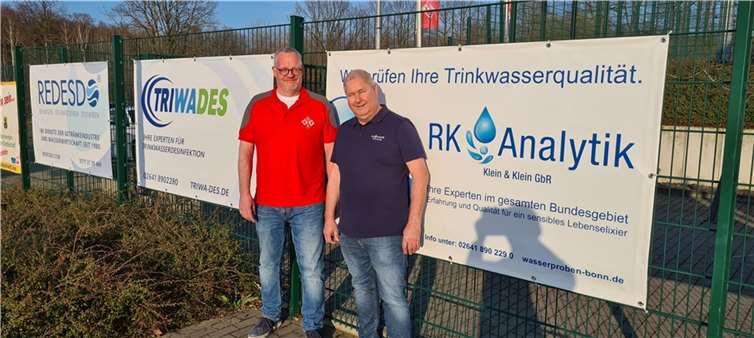 GSV-Vorsitzender Ludger Hoppe (l.) und Ralf Klein nach der Anbringung des neuen Werbebanners auf der Sportanlage in Vettelhoven. Foto: Grafschafter Spielvereinigung (GSV)