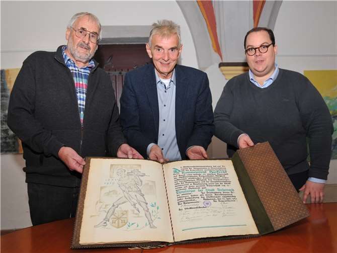 Gabriel Herfeldts Nachkomme Gerhard Herfeldt (links) übergibt die Ehrenbürgerurkunde an Bürgermeister Claus Peitz und Museumsleiter Dr. Kais Seebert (rechts).  Foto: Stadt Andernach/Maurer