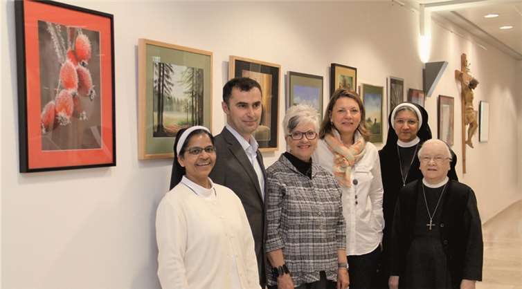 Gaby Frömbgen, Krankenhausoberin (4.v.l.), und Blerim Hetemi, Pflegedirektor des Marienhaus Klinikums, freuen sich über die Ausstellung von Künstlerin Petra Hörsch (3.v.l.) im Krankenhaus Maria Hilf. privat