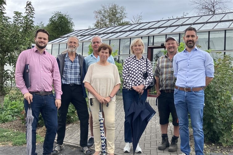 Gästeführer und Team der Perspektive vor dem Glashaus des Permakultur-Geländes
