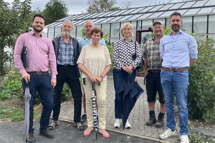 Gästeführer und Team der Perspektive vor dem Glashaus des Permakultur-Geländes