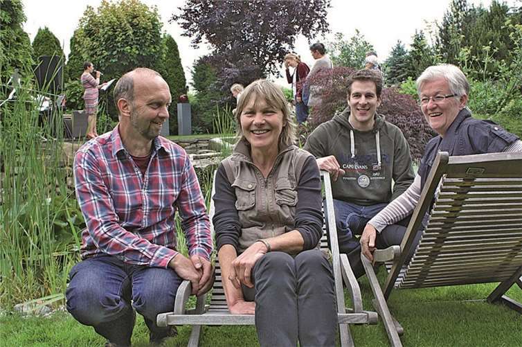 „Dunkelrote Callas an gewundenem Geäst“