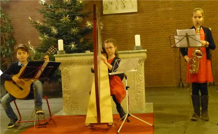 Gavin, Katharina und Emilia präsentieren konzentriert vorweihnachtliche Lieder auf ihren Instrumenten. Privat