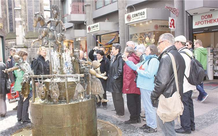 Gebannt lauschen die Teilnehmer den Worten der Führung am Puppenbrunnen in Aachen. privat
