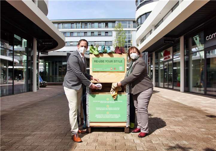 Gemeinsam für die gute Sache: Zum Startschuss der Aktion „Re-Use Your Style“ werfen Dorothea Westermayer (re.) vom Caritasverband Westerwald-Rhein-Lahn und Marcel Klomfaß (Projektverantwortlicher Montabaur The Style Outlets) die ersten Kleidungsstücke in die neu aufgestellte Fashion Charity Box im Outlet-Center in Montabaur. Foto: Janine Brügmann