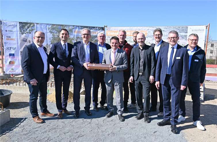 Gemeinsam griffen sie zur Zeitkapsel , von links: Heinz-Peter Witt (Technischer Beigeordneter), Jonathan Grunwald (MdL), Bert Sluyter (Niederlassungsleiter und Prokurist des Generalunternehmers Ten Brinke), Landrat Sebastian Schuster, Bürgermeister Holger Jung, Peter Hauck (Leiter der Geschwister-Scholl-Hauptschule), Dirk Schnelle (Ministerialdirigent, NRW-Ministerium für Schule und Bildung), Guido Handschmann (Architekt und Vorstand bei SSP AG), Dirk Bahrouz (Leiter des Konrad-Adenauer-Gymnasiums), Hans Dieter Wirtz (Erster Beigeordneter) sowie Andreas Satzer (Leiter des städtischen Fachbereichs Gebäudemanagement).Foto: Stadt Meckenheim