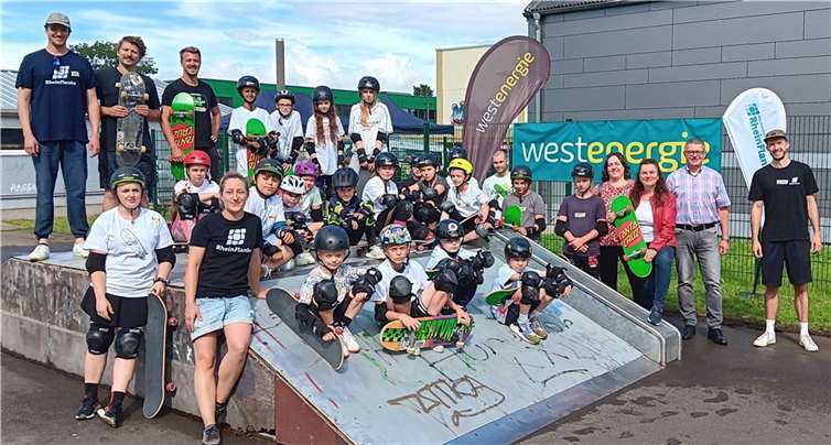 Gemeinsam mit David Weyel von der städtischen Kooperationspartnerin RheinFlanke, dem Ersten Beigeordneten Hans Dieter Wirtz, der Kommunalmanagerin bei Westenergie Lydia Bauer und der städtischen Jugendhilfeplanerin Annika Starke-Mutschler (von rechts) freuen sich die Teilnehmenden und Betreuenden auf den Skate-Workshop am Schulcampus. Foto: Stadt Meckenheim