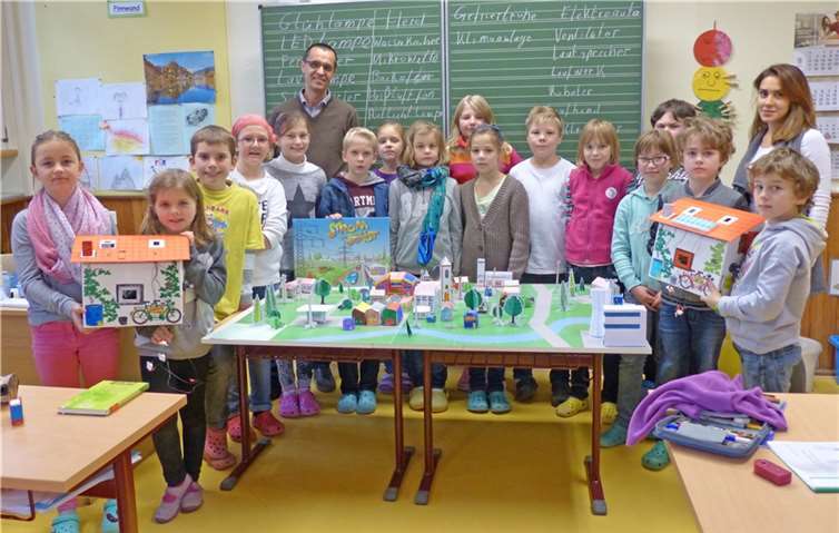 Gemeinsam mit RWE-Energiebotschaft Kurt Hürter und Klassenlehrerin Elisabeth Roth bauten die Schüler der vierten Klasse das Landschaftsmodell „Strom für unsere Stadt“ auf.privat