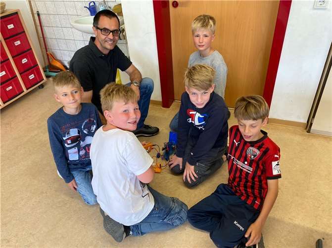 Gemeinsam mit dem Energieexperten Kurt Hürter haben die Schülerinnen und Schüler ein Brennstoffzellen-Modellauto zum Fahren ebracht.  Foto: Westenergie