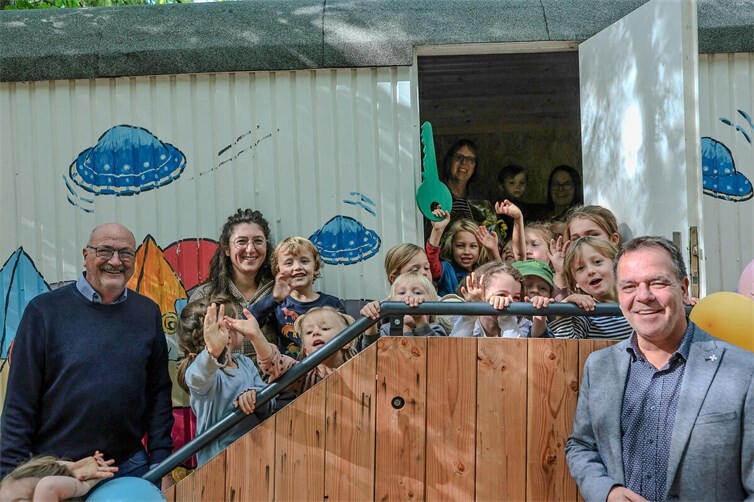 Gemeinsam mit den Kita-Kindern freuen sich Ortsbürgermeister Jürgen Schwarzmann, Quartiersmanagerin Tamara Monreal, Kindergartenleiterin Susanne Kny und Thomas Münzer, Geschäftsführer der Perspektive gGmbH (v.l.n.r.) über den neuen Bauwagen.