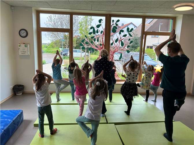 Gemeinsam mit ihrer Erzieherin Annette Strakerjahn üben sie verschiedene Yogastellungen, die den Kleinen und Großen sichtlich Spaß machen. Foto: Mareike Glabow