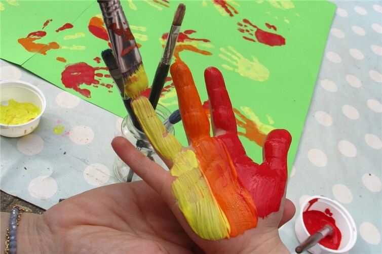 Gemeinsam wird ein Osterfeuer mit bunten Händen gestaltet.