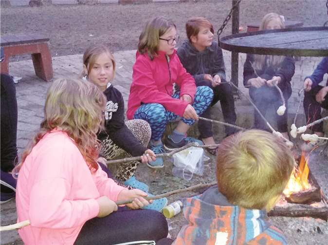 Gemütlich am Lagerfeuer beisammen sitzen und Stockbrot grillen gehört zu den Abenteuern der Sommerferien. privat