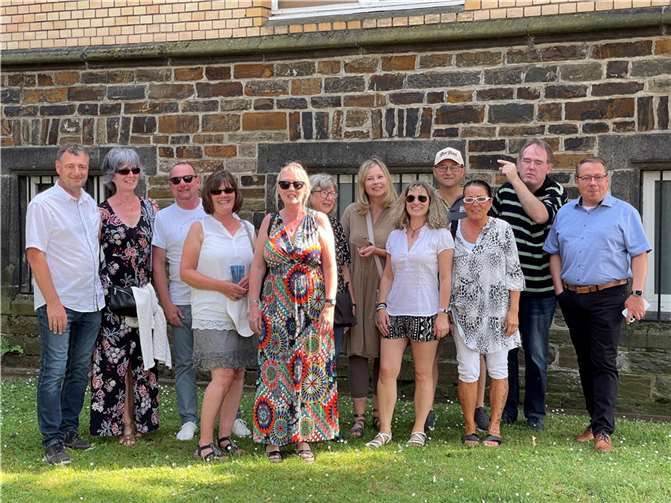 Genau unter den Fenstern hinter denen sie ihre ersten beiden Schuljahre verbrachten, haben sie sich dann zum gemeinsamen Foto aufgestellt. Torsten Quirmbach zeigt nach oben, wo sie vor 50 Jahren aufgeregt den ersten Schultag erlebten. Ein Gänsehautmoment.. Foto: Hans-Georg Reininger