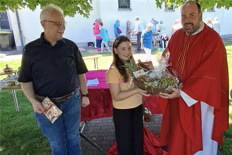 Georg Kluth (3. Platz), Lotta Engbert (1. Platz) und Pfarrer Michel Maxeiner bei der Überreichung der Preise nach der hl. Messe zu Pfingstmontag