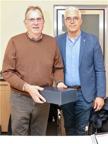Georg Knieps (li.), Erster Beigeordneter der Verbandsgemeinde Altenahr, wurde kürzlich für seine vielfältige ehrenamtliche kommunalpolitische Tätigkeit mit der Freiherr-vom-Stein-Plakette ausgezeichnet. Bürgermeister Dominik Gieler (re.) gratulierte zu der Auszeichnung mit einem Präsent und bedankte sich vor der jüngsten Sitzung des Haupt- und Finanzausschusses für Knieps jahrzehntelanges Engagement. Foto: VG Altenahr / Thorsten Trütgen