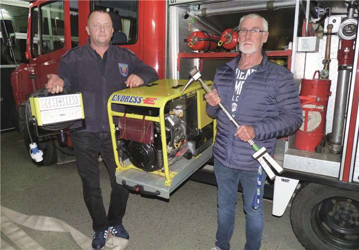 Gerätewart Hans Joachim Sänger mit dem vom Förderverein finanzierten „Halligan Tool“ sowie der stellvertretende Wehrführer Lars Perzewski mit einem von zwei ebenfalls vom Förderverein finanzierten LED-Scheinwerfern.