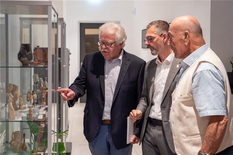Gerd Heim, Philipp Lohse und Karl-Heinz Urmersbach (von links nach rechts) schauen die Artefakte an.