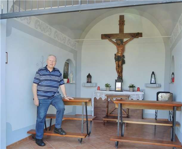 Gerd Kaul in der fertiggestellten Missemer Hochkreuz-Kapelle. Der in Pastelltönen gestrichene Altarraum mit den "italienischen" Ornamenten sowie den neu lackierten Bänken der Kapelle ist ein echter Hingucker. Im Hintergrund der kleine Altar mit dem in Tirol angefertigten 1,40 m hohen Holzkreuz. Fotos: Manni Puth