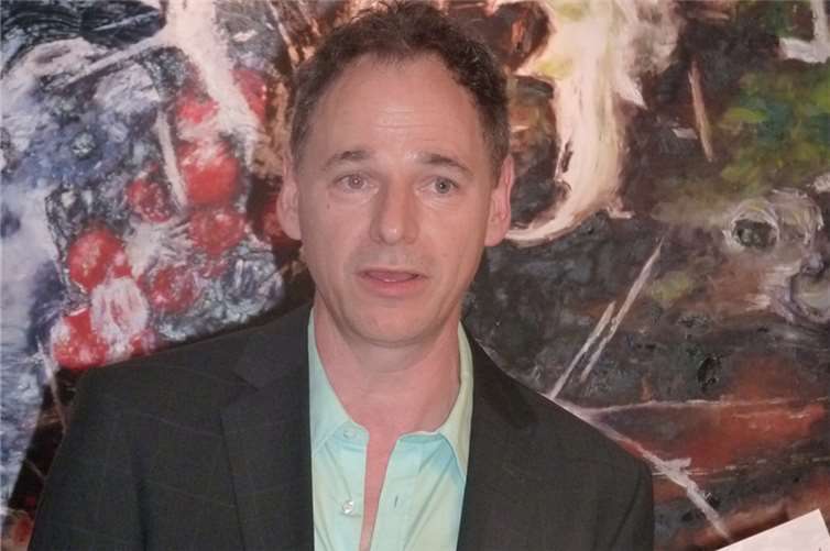 Germania-Geschäftsführer Budweg stellt die Ausstellungsbroschüre vonNicolas Maneth vor und erläutert deren Inhalt.