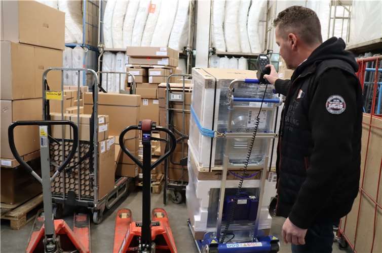 Geschäftsführer Dirk Körting zeigt den Teilnehmenden der Inklusionsrundreise zum Thema Arbeit in seiner Westerwald-Logistik GmbH in Moschheim, wie durch Erleichterungen im Betriebsablauf und technische Neuerungen Arbeitsplätze auch für Menschen mit einer Behinderung entstanden sind.