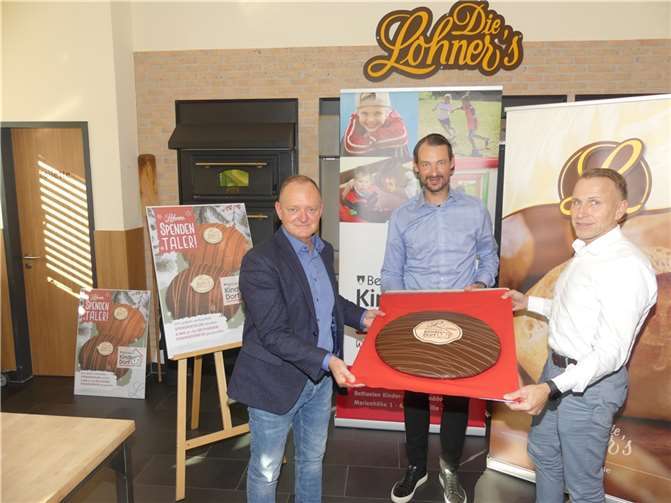Geschäftsführer Helmut Moll und Marc Kranz (v.r.) präsentieren mit Thomas Kunz (Bethanien Kinderdörfer) einen Spendentaler in Großformat.Fotos:TE