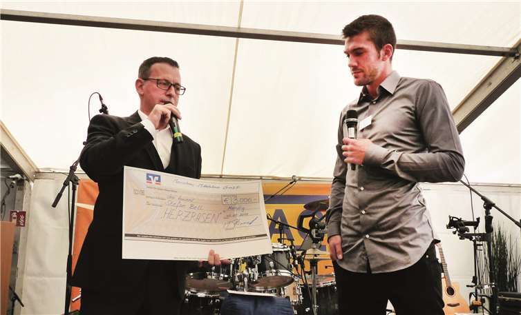 Hausbauunternehmen ist auf solidem Wachstumskurs  Geschäftsführer Marcus Fronert überreichte dem Profi-Sportler Stefan Bell für dessen Projekt „Herzrasen“ einen Scheck über 3.000 Euro.