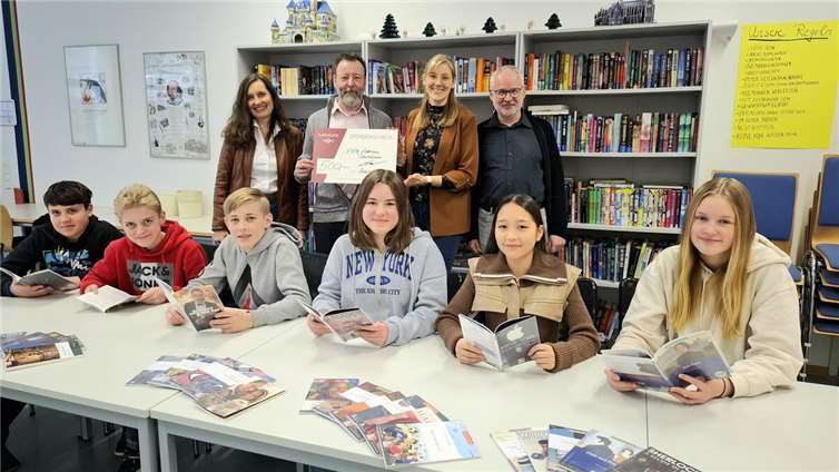 Geschäftsführer Oliver Follmann und Petra Raeder, Assistentin der Geschäftsleitung und ehemalige Schulelternsprecherin am EKG, übergeben ihre Spende von 500 Euro symbolisch an Laura Wehren und Bernhard J. Müller vom Fachbereich Englisch.  Foto: Volker Kämpf