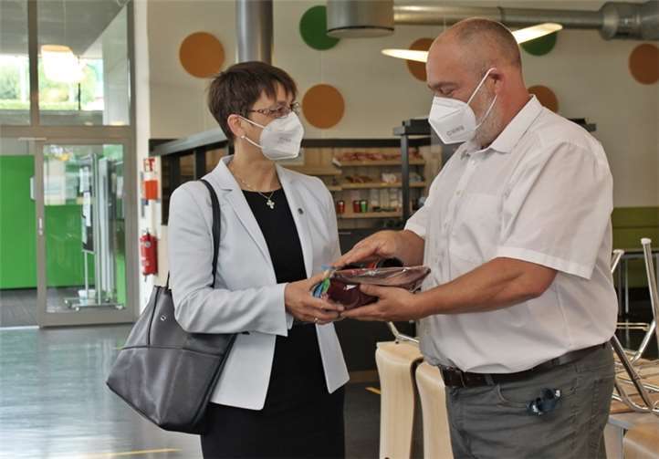 Geschäftsführer René Roos überreicht Pröpstin Bertram-Schäfer ein Willkommensgeschenk.