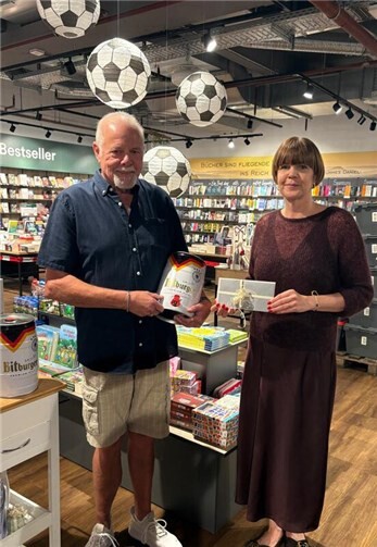 Geschäftsleiterin Pia Lancier überreicht dem Zweitplatzierten Jürgen Schneemann seinen Gewinn – einen 50-Euro-Gutschein der Metzgerei Windolf und ein 5-Liter-Fässchen Bitburger Pils.  Foto: Moses AG