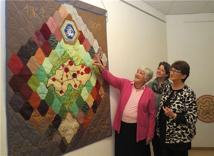 Geschenk zum Gemeindejubiläum: Gertrud Theis (li.) erläutert BMin Renate Offergeld (re.) und Stefanie Weißenfels ihren Wachtberg-Quilt.Foto: Gemeinde Wachtberg/mm