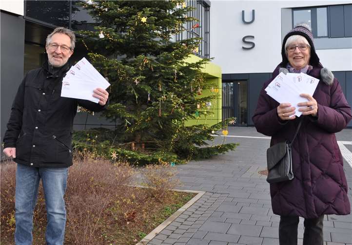 Geschenkübergabe vor dem Rathaus: Jürgen Elsen-Bollig vom städtischen Fachbereich Jugendhilfe und Anita Grundmann von der Schuh- und Kleiderstube mit den Kuverts für die Familien.Foto: Stadt Meckenheim