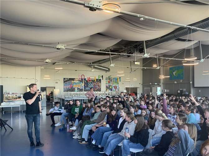 Gespannt stellen die Kinder dem BKA-Beamten Andy Neumann im Rahmen der Lesung des Buches „Was ist Was – Polizei-. Für dich im Einsatz“ Fragen.  Foto: Lisa Steinfort