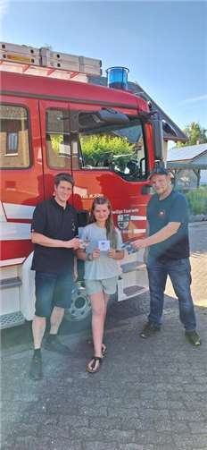 Spiel ohne Grenzen zum Jubiläum: 30 Jahre Jugendfeuerwehr Kürrenberg Gewinnübergabe mit (v.l.) Jugendwart Uwe Gilles, Leonie Beck und stellv. Jugendwart Markus Wagner.