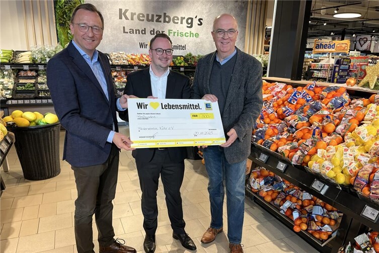 Gleich nach der Schicht an der Supermarktkasse überreichten der Koblenzer Bundestagsabgeordnete Josef Oster (links) und Edeka-Geschäftsführer Alexander Kreuzberg (Mitte) den symbolischen Scheck an den Vorsitzenden des Vereins der Freunde und Förderer des Herz-Jesu-Hauses Kühr, Paul Kreutz. Foto: Michaela Cetto