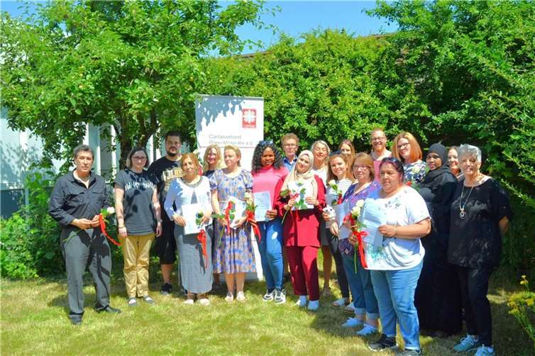 Glücklich halten die Absolventinnen und Absolventen ihre Zertifikate und Rosen in den Händen. Mit dem Abschluss im Bereich qualifizierende Vorbereitung zur Alten- & Krankenpflegehilfeausbildung und Betreuungsassistenz haben sie ihren beruflichen Weg gefunden. Foto: Eberhard Thomas Müller