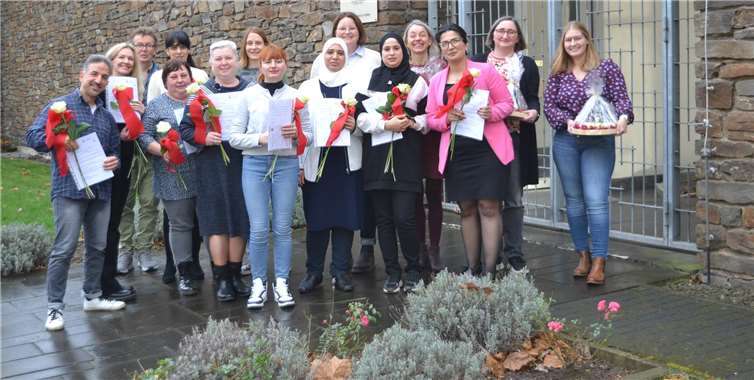 Glücklich halten die Absolventinnen und Absolventen ihre Zertifikate und Rosen in den Händen. Mit dem Abschluss im Bereich qualifizierende Vorbereitung zu einer Ausbildung oder Beschäftigung in der Alten- & Krankenpflege finden sie ihren beruflichen Weg.  Foto: Eberhard Thomas Müller