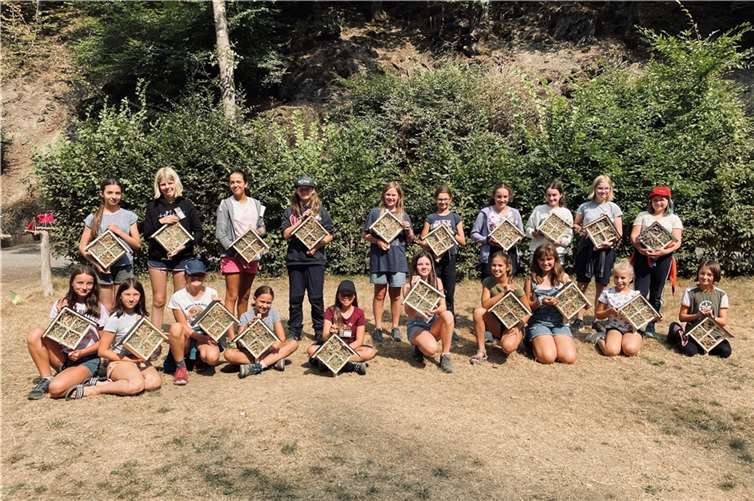 Glücklich präsentieren die jungen Teilnehmerinnen des Sommerferiencamps 2022 des Ada-Lovelace-Projekts im Pfadfinderlager Brexbachtal ihre selbst gebauten Insektenhotels.  Foto: Universität Koblenz-Landau