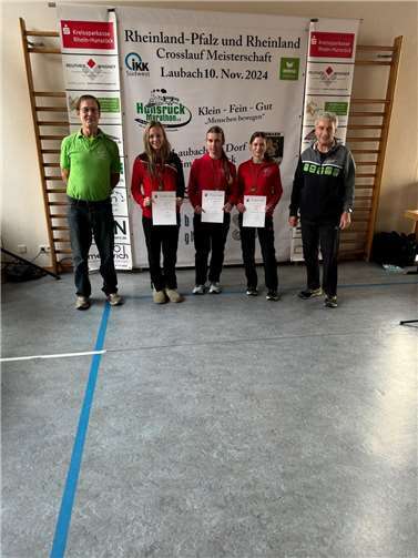 Gold gewann die weibliche U18-Mannschaft der LG Rhein-Wied mit Lia Smolka, Alina Forkert und Laura Köhler bei der Rheinland-Pfalz- Cross-Meisterschaft in Laubach/ Hunsrück. Der Kreisvorsitzende Michael Gröhning und Laufwart Klaus Jahnz rahmen die Meisterinnen auf dem Foto ein.  Quelle: LG Rhein-Wied