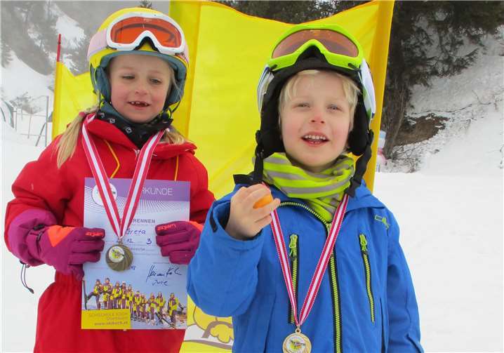 Greta und Janno zeigen Stolz ihre Medaille, ihre Urkunde und ihr Osterei.