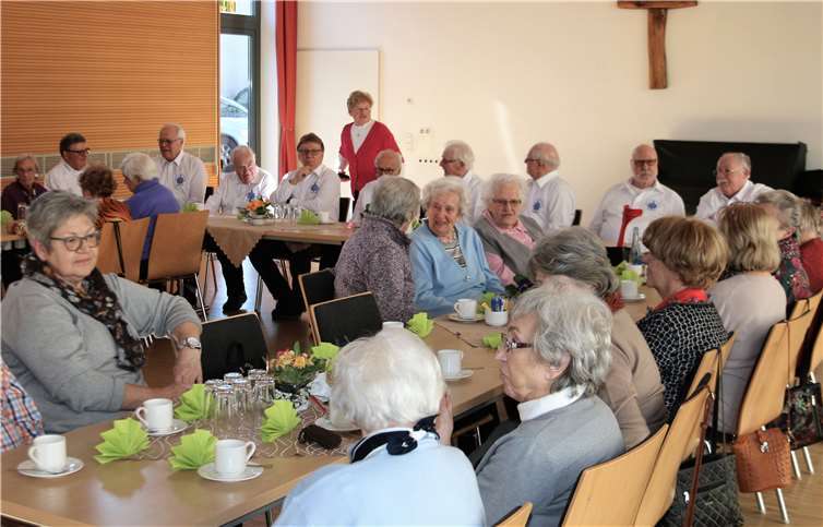 Gretel Buhr (stehend) begrüßt die Gäste sowiedie „Evergreens“ zum Frühlingskaffee im Pfarrheim. G. Schuch